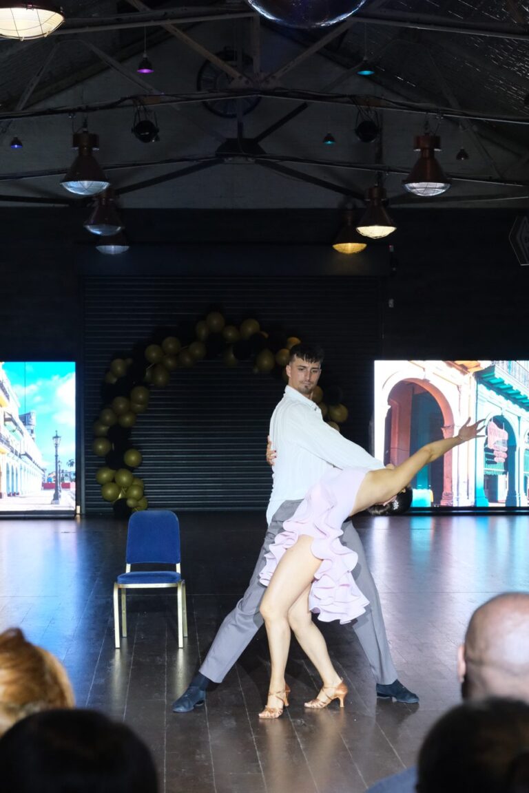 A couple performing a first dance routine in a long pale dress